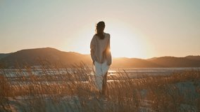 Silhouette girl meditating sunrise raising hands to clear sky back view. Carefree woman surrounded dry grass swaying on wind enjoy golden sunlight. Happy brunette contemplating bright sunset horizon. - Powered by Shutterstock - Get 15% off with code: PIKWIZARD15