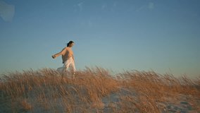 Happy brunette walking sunny nature enjoying summer wind. Carefree young woman spinning with spread out hands stepping on dry grass. Relaxed traveler exploring beautiful nature grassland. Rest concept - Powered by Shutterstock - Get 15% off with code: PIKWIZARD15