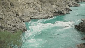 Cold ice water river or stream flowing strong powerful current or rapid. Turquoise colored water flow downstream between gray solid rocks in valley in South Island in New Zealand during winter - Powered by Shutterstock - Get 15% off with code: PIKWIZARD15