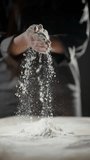 Professional chef generating dramatic flour dust cloud by forcefully clapping hands, white powder particles suspending against dark culinary workspace - Powered by Shutterstock - Get 15% off with code: PIKWIZARD15