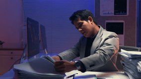 Stressed businessman working late at night, analyzing financial documents and experiencing intense challenges during stock market crisis, reflecting professional pressure and determination - Powered by Shutterstock - Get 15% off with code: PIKWIZARD15