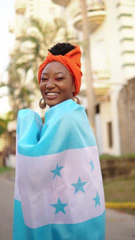 Portrait of a smiling garifuna woman wrapped in the honduran flag
