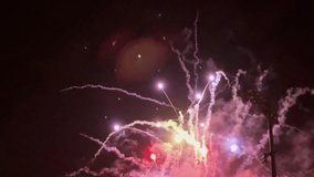 Real-time shot of colorful fireworks exploding over a baseball stadium, against a pitch black sky.   - Powered by Shutterstock - Get 15% off with code: PIKWIZARD15