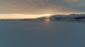Expansive Arctic snowfields reflecting warm light of setting sun in Iceland winter, drone ascend - Powered by Shutterstock - Get 15% off with code: PIKWIZARD15