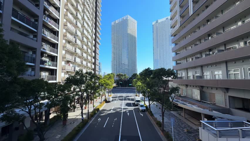 A modern cityscape of Harumi, Tokyo, showing tall buildings and a wide street