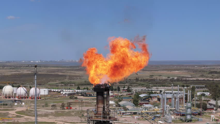 Close-up drone view of the huge flames coming out the industrial refinery tower, Bahía Blanca, Province of Buenos Aires, Argentina.