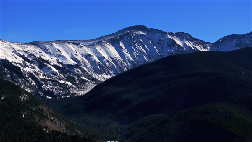 Colorado Rocky Mountain National Park Fraser Berthoud Corona Pass Winter Park ski resort mountain town aerial drone winter December snow blue sky sunny blanket of snow circle right motion