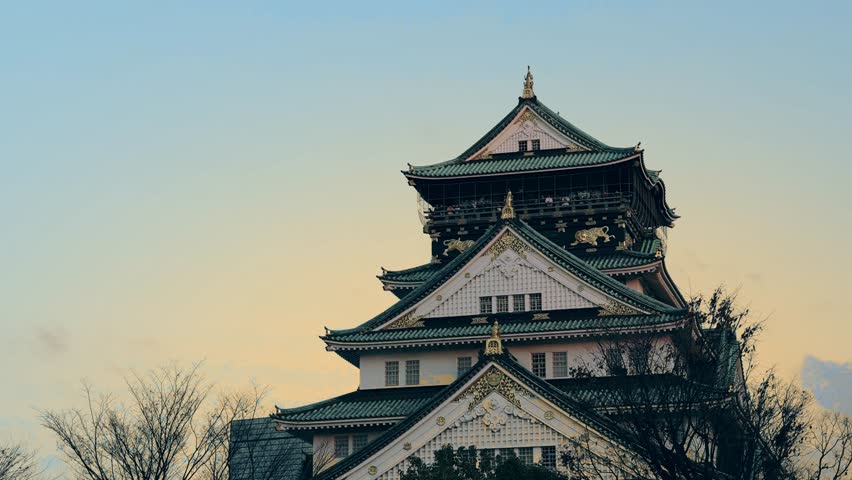 Osaka Castle. A majestic view of Osaka Castle in Japan during a serene evening January. Historical architecture Osaka castle stands tall with golden details under evening sky. Landmark for traveller.