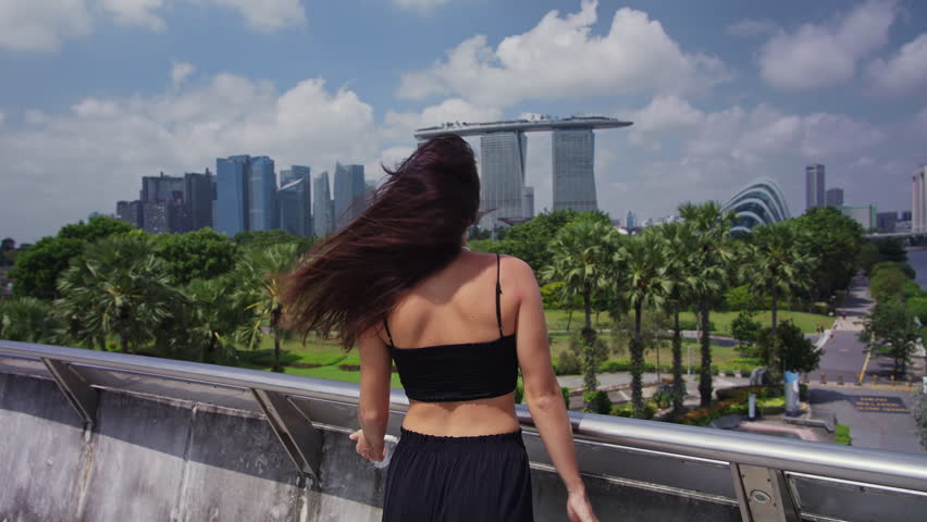 Woman pointing at Marina Bay Sands Singapore skyline