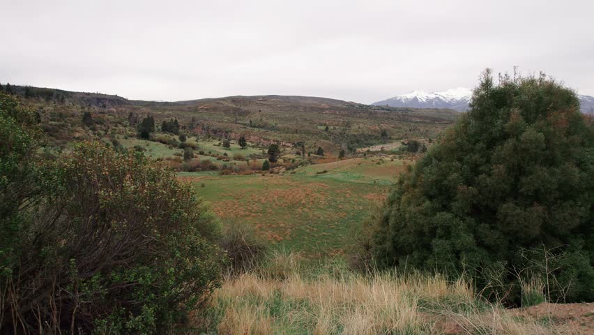 Patagonian Landscape near Esquel, Argentina, with Hills, Grasslands, and Snowy Peaks