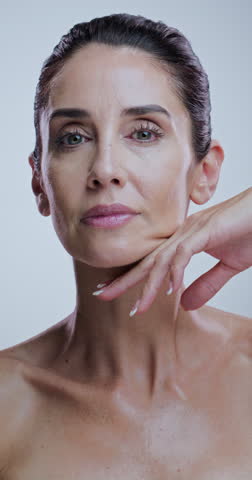 Skincare, hands and face of woman in studio for anti aging, cosmetics and wrinkle treatment. Dermatology, touch and portrait of mature person for beauty, spa and glow of natural texture on background