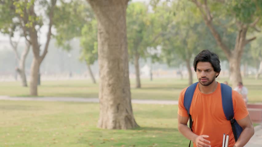 Young Indian Male College Student Fast Walking