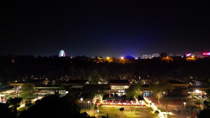 Nighttime view of a vibrant city skyline with lights and attractions