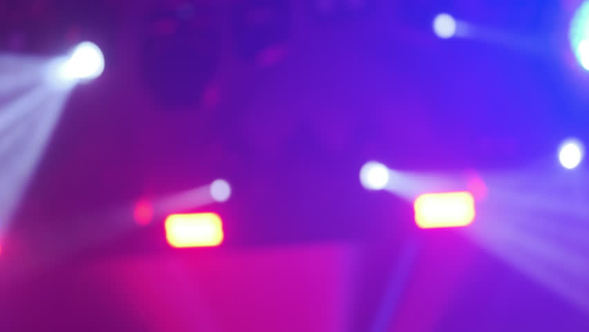 Out-of-focus concert lighting revealing vibrant blue and white spotlights creating a surreal ambiance