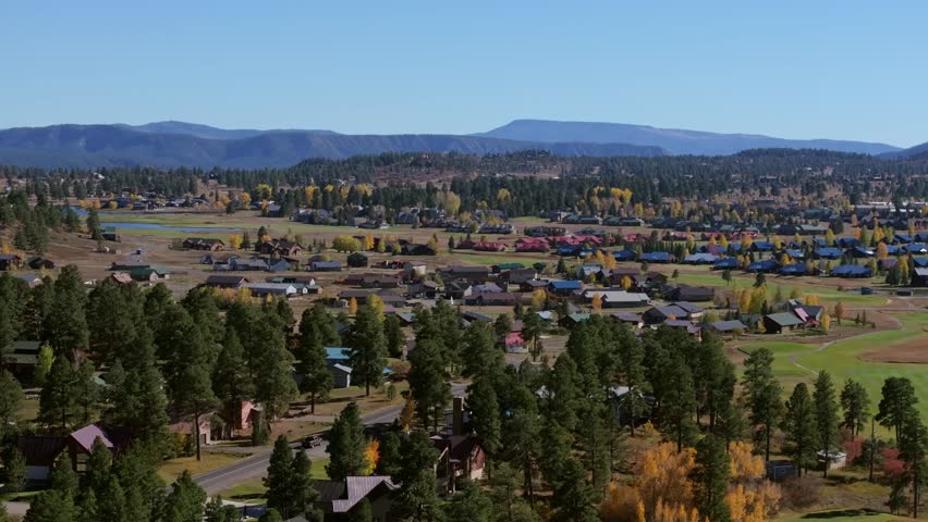 A scenic view of Pagosa Springs, Colorado with green forests and colorful autumn homes