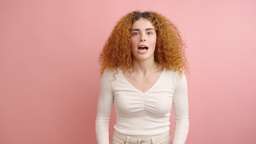 Young woman expressing joy and excitement in studio setting