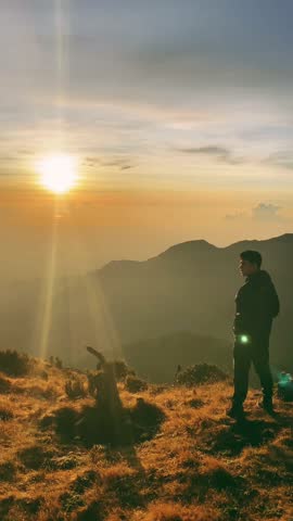 a man with a sunrise over a mountain. enjoy views of mountains, valleys and cool morning air with morning sunlight