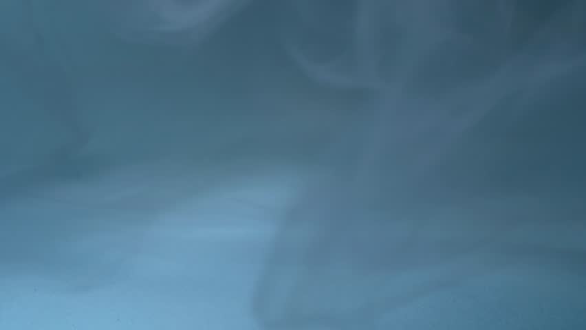 Blue wisps of smoke swirling swirling medium 4k shot selective focus