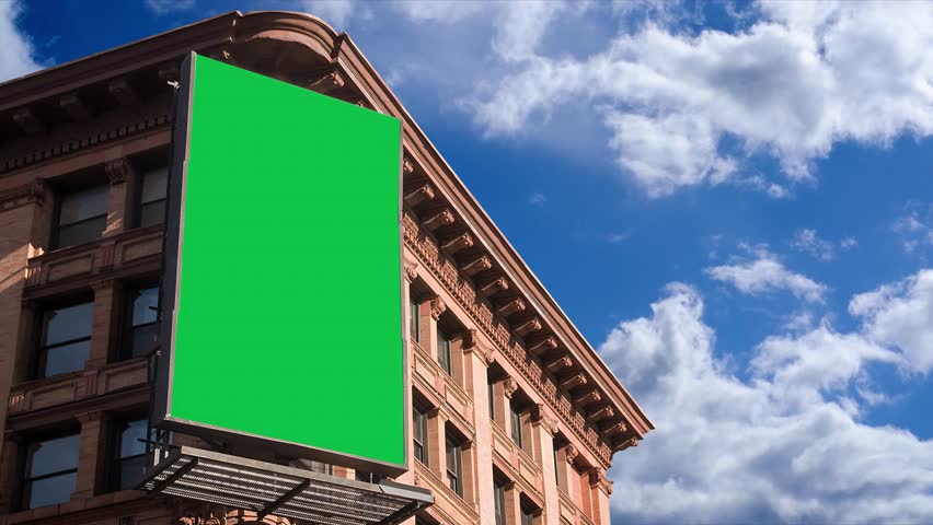 Large billboard with a green screen for advertising on the building wall.