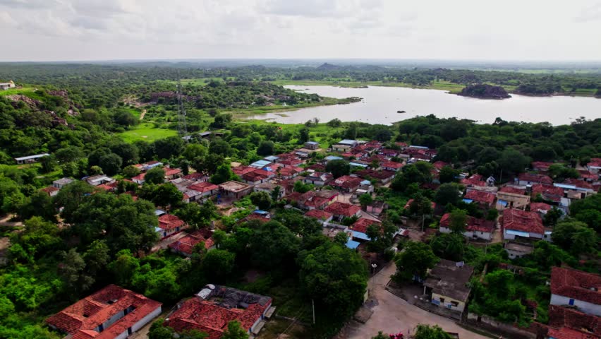 Nountiled houses with greenery, lake, sky and clouds at yelupugonda village, Tekmal, telangana, india. day time, push back, drone shot, 4k.