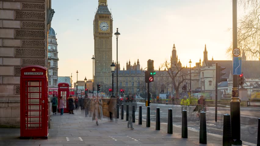 Time lapse view of red telephone booths in front of Big Ben clock tower and Westminster in London during morning rush hour
