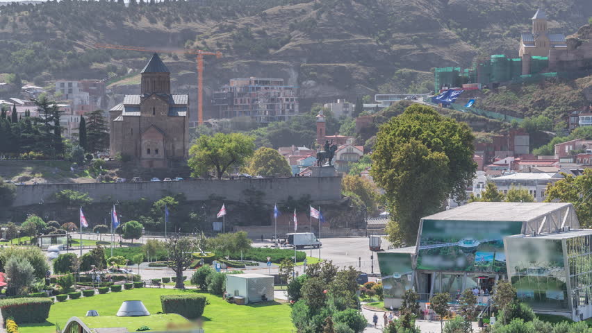 Metekhi Virgin Mary Assumption Church aerial timelapse and the Statue of King Vakhtang Gorgasali above the Kura River. Green trees and lawn in Rike Park. Tbilisi, Georgia.