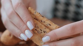 Hands breaking a seeded cracker, Close-up of hands breaking a crunchy cracker with seeds. - Powered by Shutterstock - Get 15% off with code: PIKWIZARD15