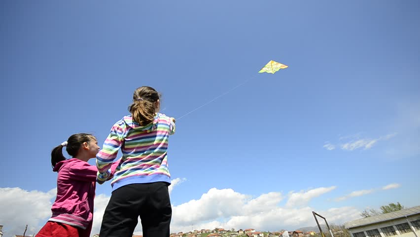 Young girl kids flying a kite, wide angle