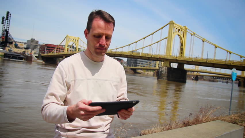 A man uses his tablet PC outside.