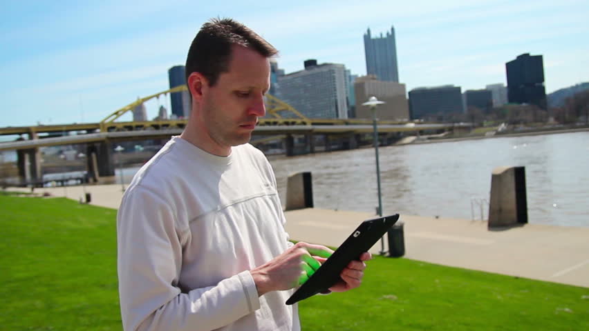 A man uses his tablet PC outside.