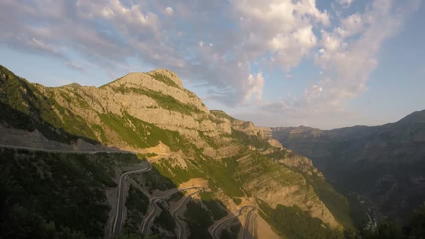timelapse of epic roads in the north albanian mountains, famous curves and hairpin turns of SH20 road above the Cem river gorge in morning. Sun is just rising over the mountains..