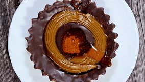Chocolate and caramel filled tart with a biscuit base, a baked pastry consisting of an outer pastry crust biscuit filled with caramel and chocolate, a snack or a treat beside a drink, selective focus - Powered by Shutterstock - Get 15% off with code: PIKWIZARD15