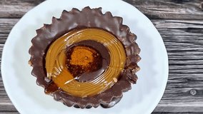 Chocolate and caramel filled tart with a biscuit base, a baked pastry consisting of an outer pastry crust biscuit filled with caramel and chocolate, a snack or a treat beside a drink, selective focus - Powered by Shutterstock - Get 15% off with code: PIKWIZARD15