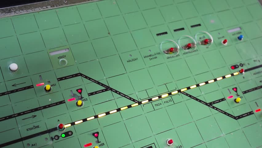 A railway control board with illuminated tracks, signals, and switches for train traffic management