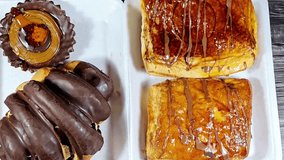 Assorted bakeries of Croissant, a buttery, flaky, viennoiserie pastry topped and filled with chocolate, Baked Danish pastry topped with jam and chocolate sauce and Chocolate and caramel filled tart - Powered by Shutterstock - Get 15% off with code: PIKWIZARD15