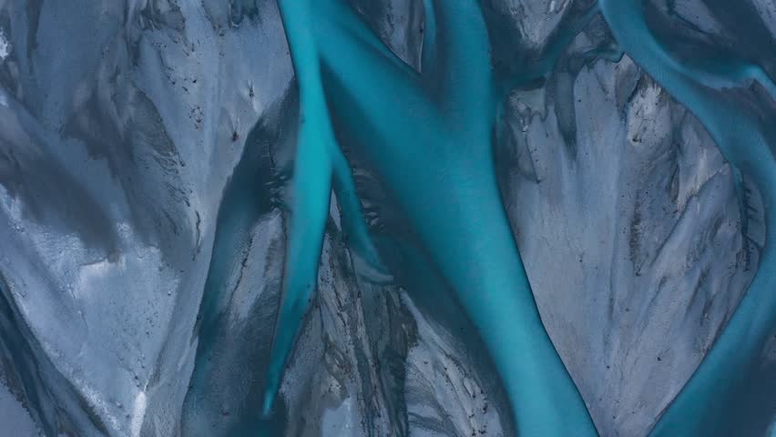 Top down aerial shot of Blue Glacial Braided River delta that looks like abstract art, Godley River, New Zealand