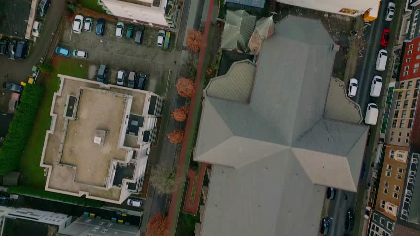 Top-down aerial footage of a city block in Oberhausen with a parking lot surrounded by residential and urban structures. Oberhausen, Germany