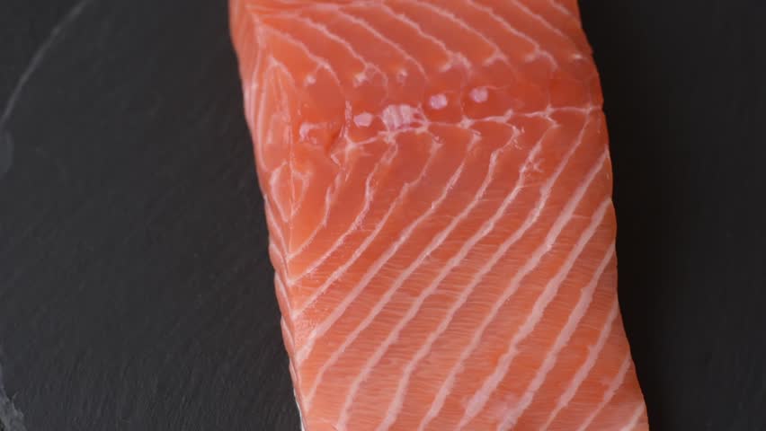 Fresh raw salmon steak with spices and herbs prepared for grilled baking. Healthy seafood food