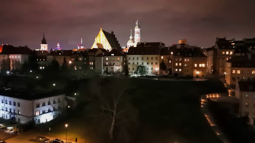 Revealing, bottom-up aerial video of Warsaw center in the night, with a old town and business district