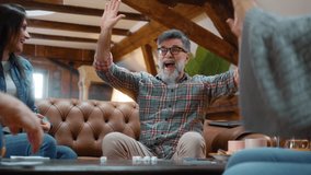 Group of retired senior friends play board games together at home in living room, throwing dice and win points, have positive reactions, and celebrate victory by giving high fives. - Powered by Shutterstock - Get 15% off with code: PIKWIZARD15