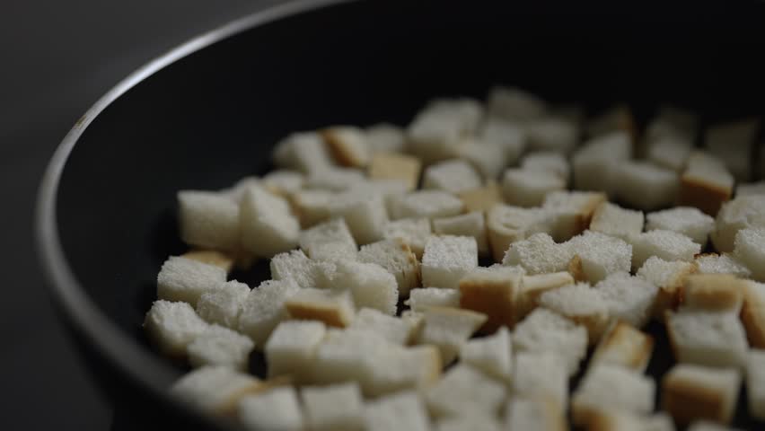 Croutons are fried in a frying pan.