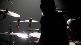 Skilled drummer punching hi-hats, playing music in rock gig, rearview in dark. Hobby and passion, young adult man rehearsing to beat rhythm, enjoy modern music, cool guy rocking crowd in concert hall - Powered by Shutterstock - Get 15% off with code: PIKWIZARD15