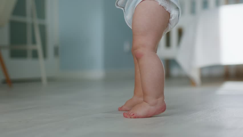 Close-up of a little baby's foot. Baby is learning to take his first steps. Slow motion video in 4K