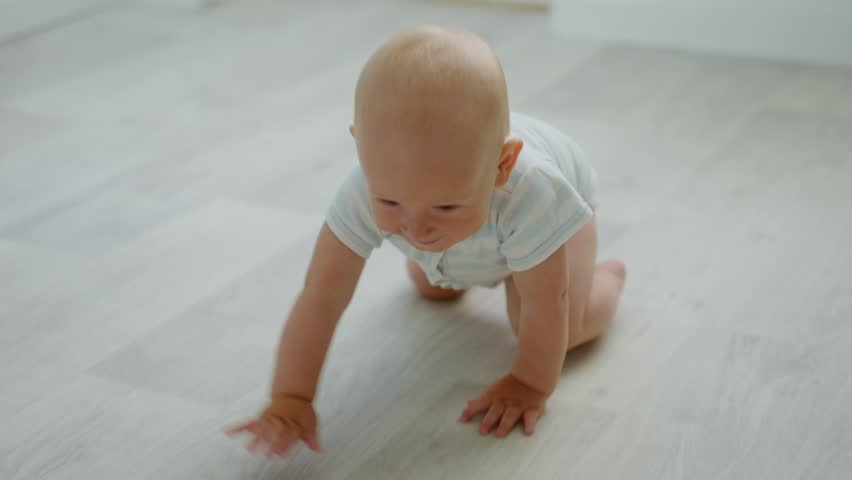 Cute baby crawling on all fours at home. Child learning about the world. Slow motion video in 4K