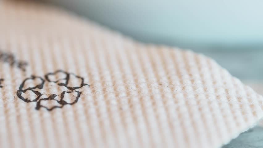 Recycling symbol on fabric in close-up from textile manufacturing