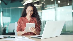 Busy young businesswoman engaged in task using digital tablet taking notes sitting at a desk at workplace. Confident female employee working in an application or planning in a modern business office - Powered by Shutterstock - Get 15% off with code: PIKWIZARD15
