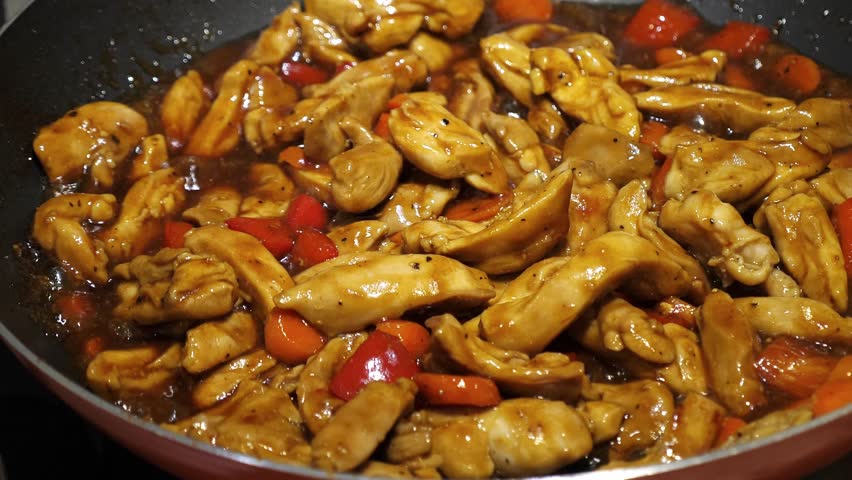 Cook teriyaki chicken on frying pan, closeup