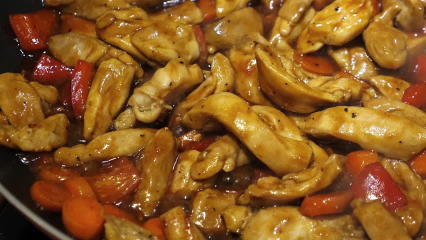 Cook teriyaki chicken on frying pan, closeup