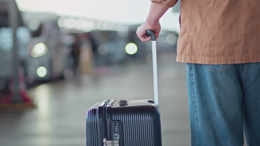 B roll - Rear View of man passenger with suitcase is waiting for taxi car, Airport taxi.