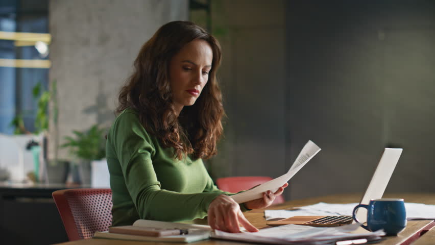 Pensive woman looking papers working office closeup. Corporate hr manager analysing documents solving problem at contemporary workplace. Stylish brunette businesswoman reading finance report at desk 